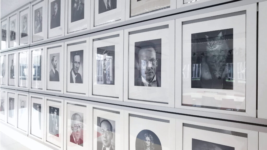 Eine Wand mit vielen schwarz-weiß Bildernvon Personen